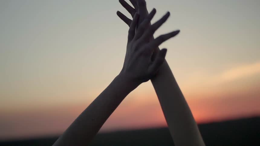 Woman outside stretching at dusk