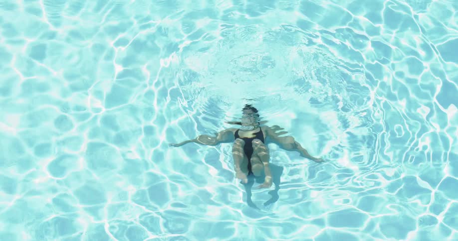 Woman moves underwater in swimming pool