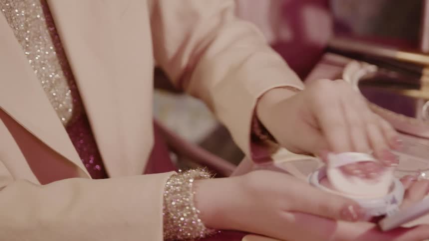 A woman is applying makeup