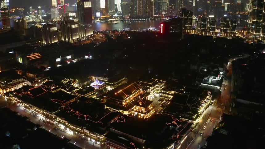 Illuminated buildings sit in the city as vehicles travel on the roads
