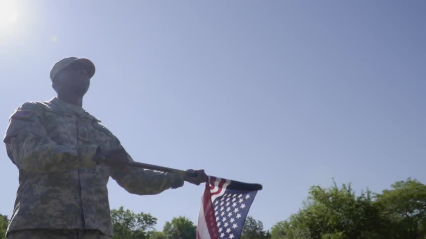 Soldier waving us flag outside