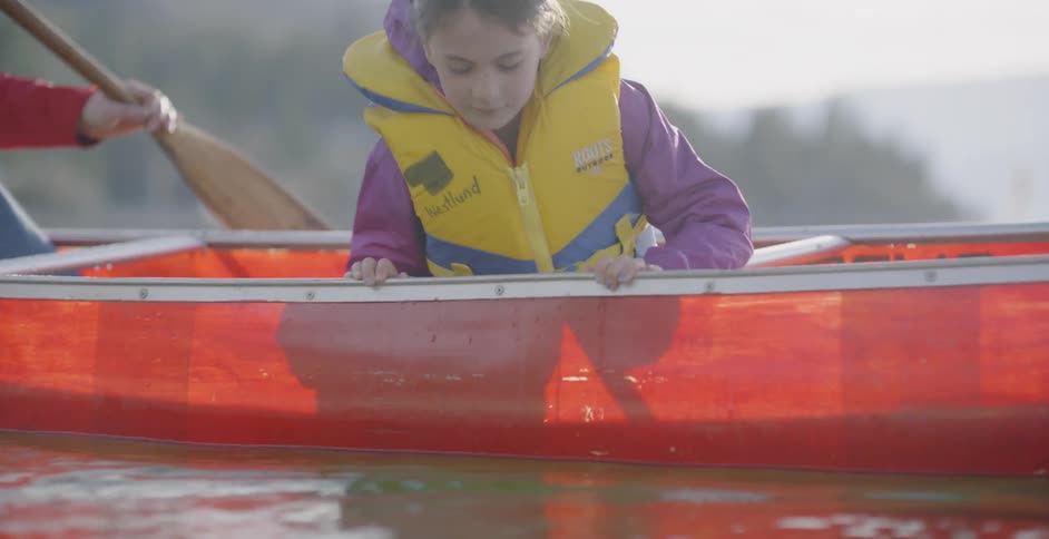 A family canoes on a mountain lake on a sunny day