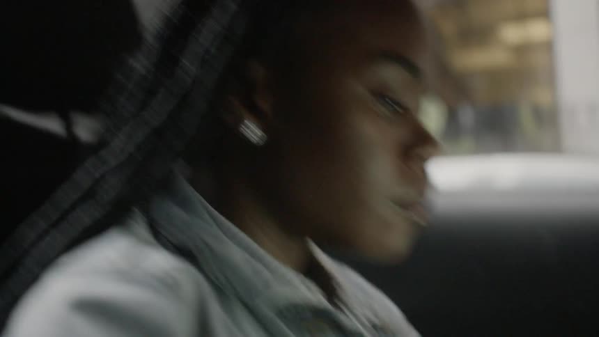 Woman works on her laptop as she travels in a car