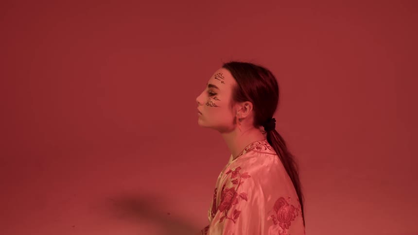 A woman turns to the side in the dark room