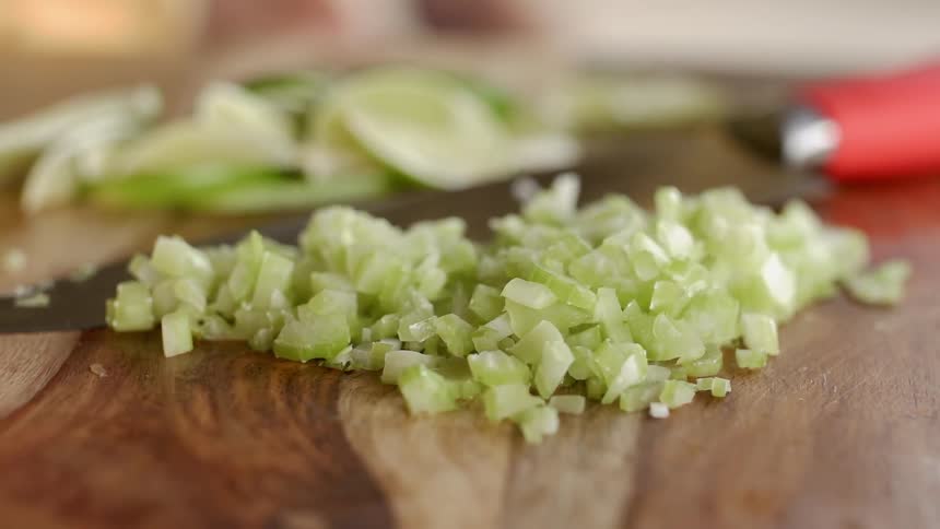 Chopped vegetables sit on a cutting board