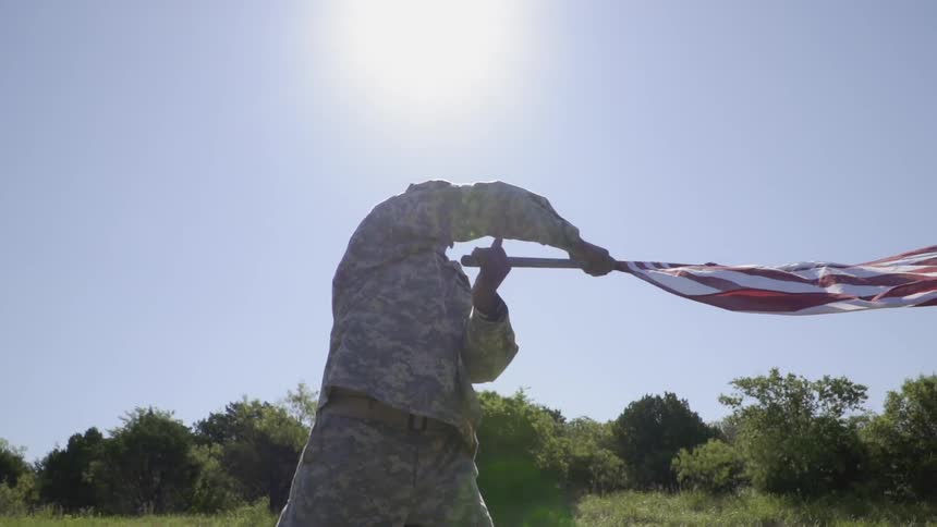 Man waves the american flag under the bright sun