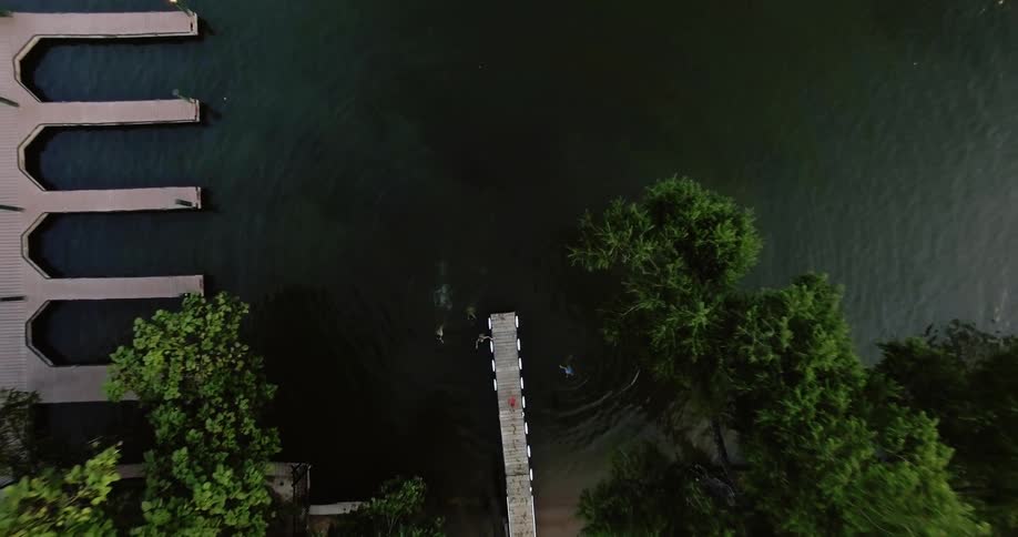 People swim towards a dock