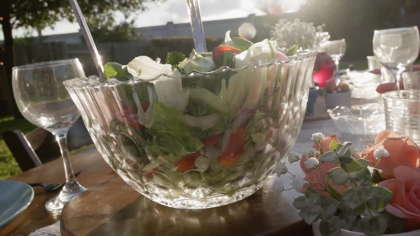 A salad bowl sits on an outdoor table