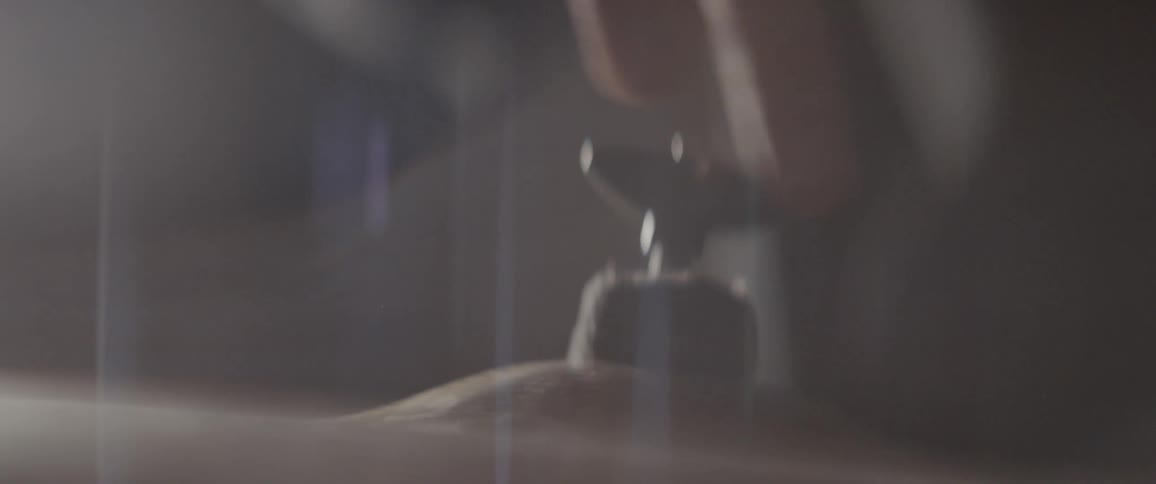 A wingnut is being secured on the top of a cymbal inside in daylight
