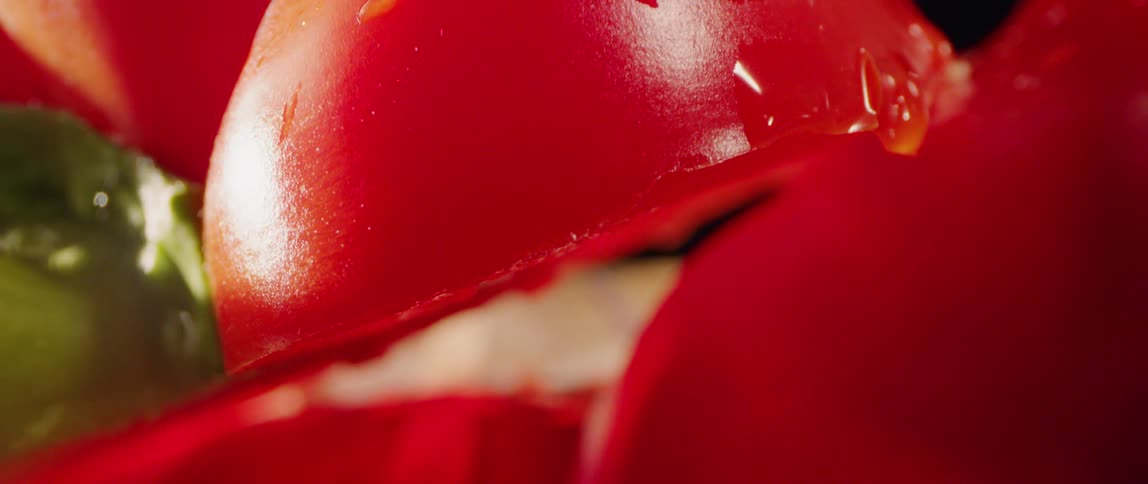 Cut tomatoes fall down on the table