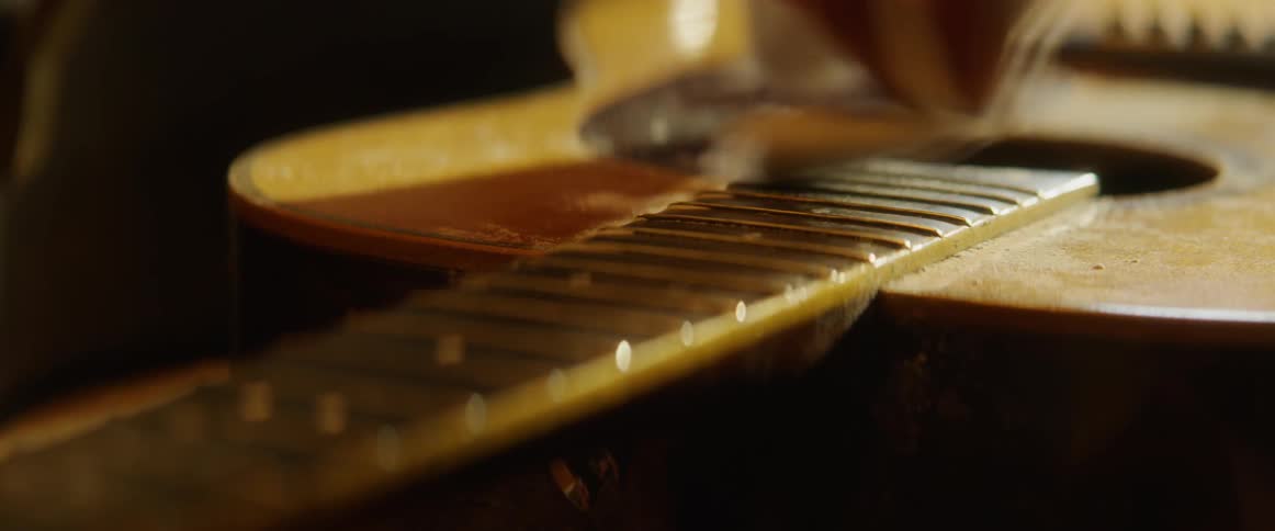 A guitar is wiped clean with a cloth