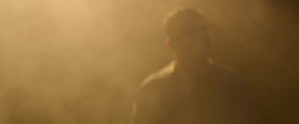The fog rolls around the man in the dark