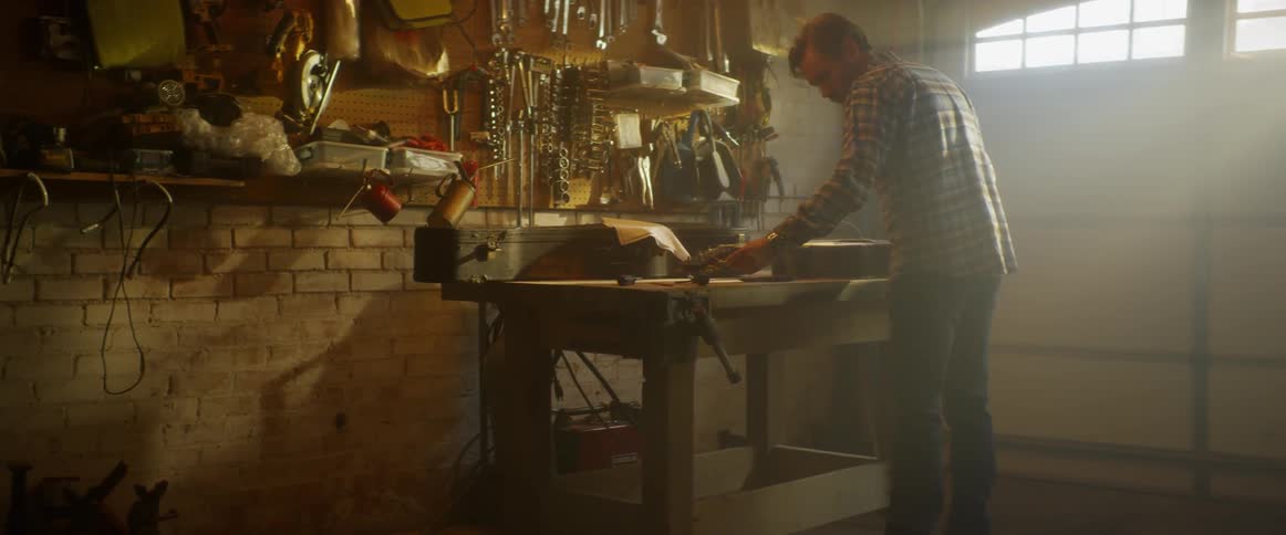 A man is working on his bench in the garage
