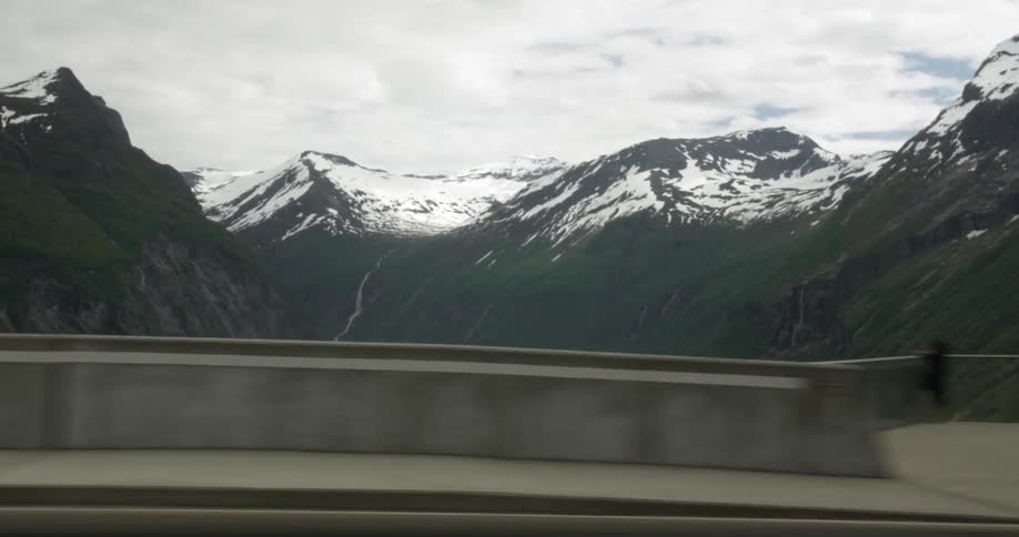 Snow covered mountains as seen from a traveling car in the daytime