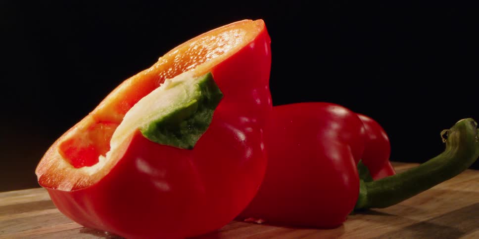 Red pepper on a cutting board sliced in half