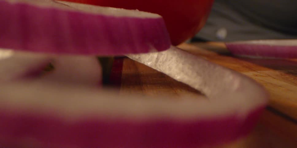 Slices of onions move on the cutting board