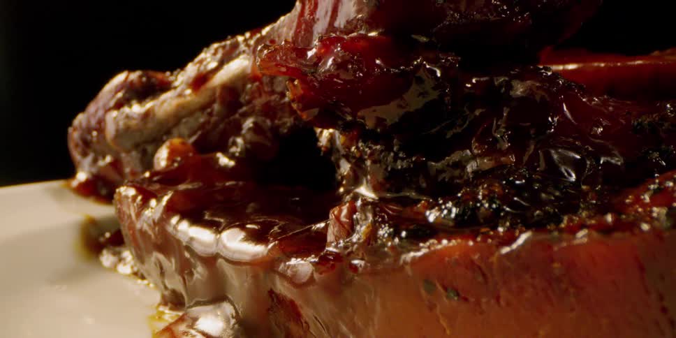 Glazed meat sits on a white plate
