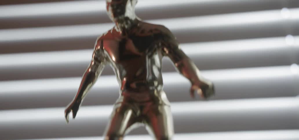 Statue of a soccer player sits in front of a window