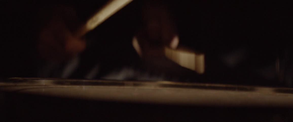 Pair of drumsticks tapping on a drum