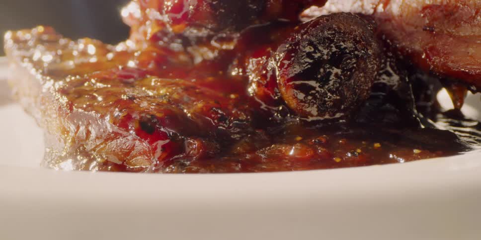 A pile of barbecued ribs are sitting on a plate
