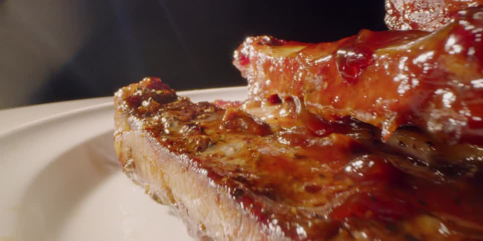 A pile of barbecued ribs are sitting on a plate