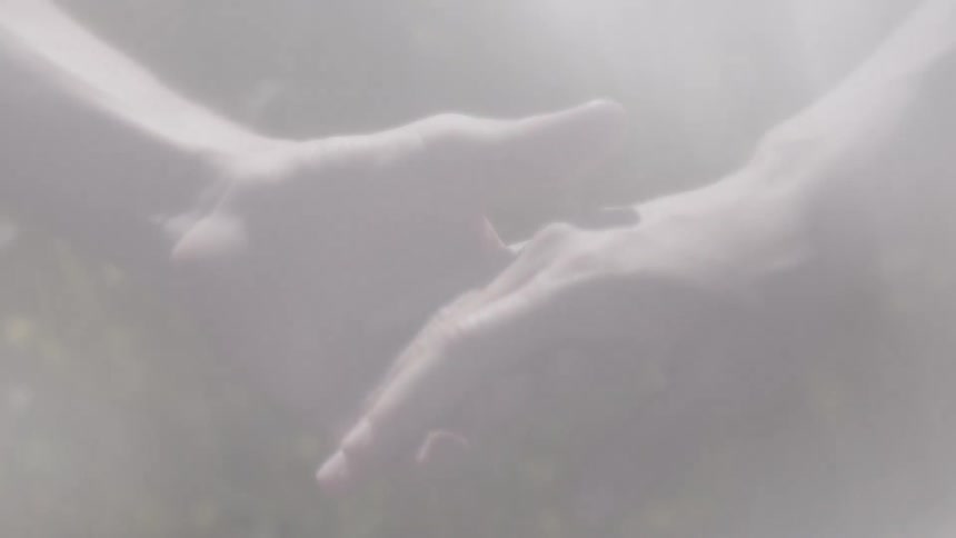 A hand reaches out to another with a veiled texture in the foreground