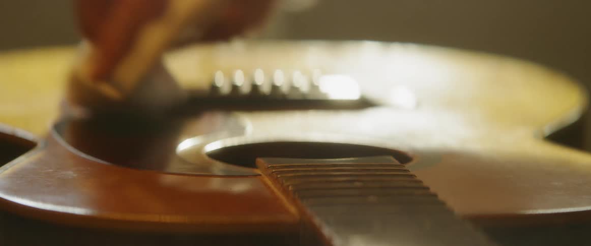 Person is wiping a guitar with cloth