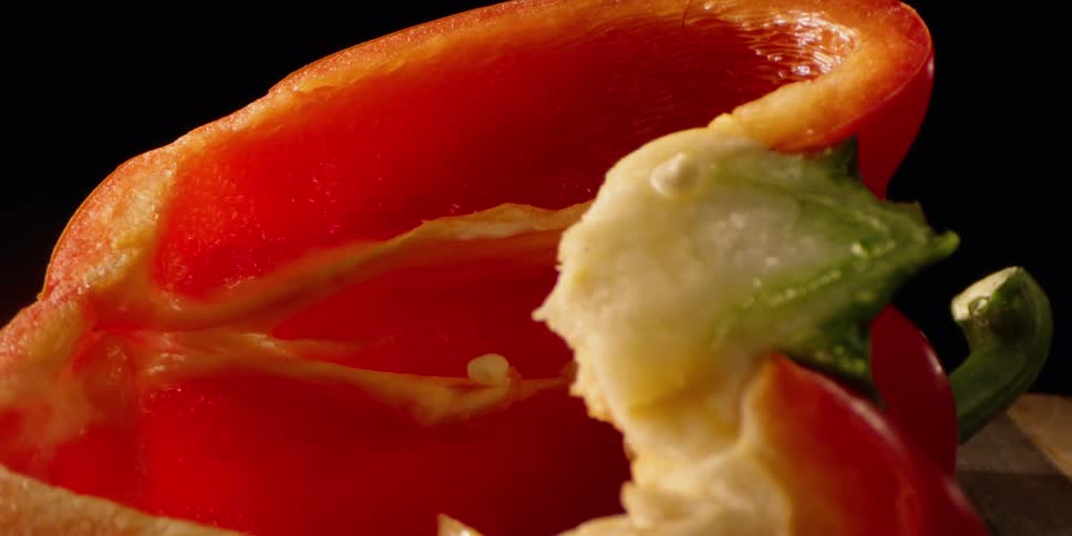 Red bell pepper cut in half on cutting board