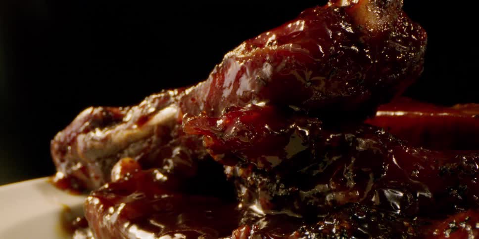 A pile of barbecued ribs are sitting on a plate