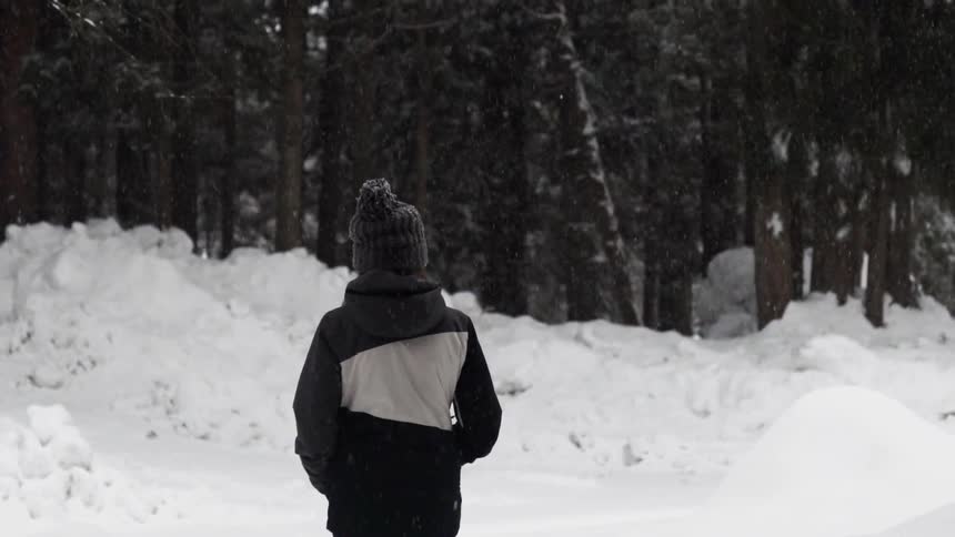 A person walks outside in the snow