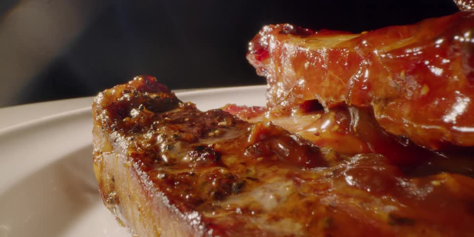 Glazed meat sits on a white plate