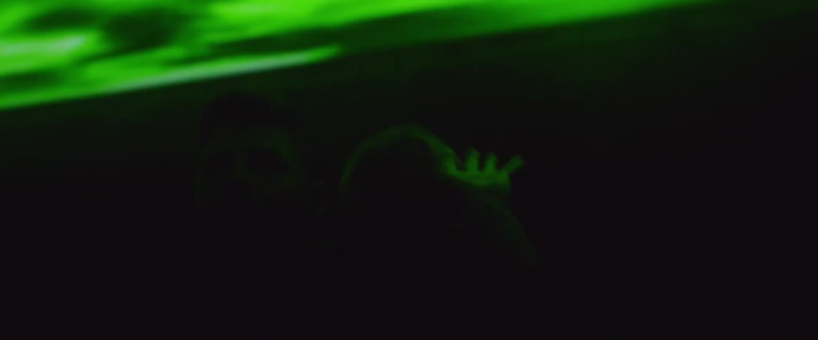 A man is attacked in a dark room with flashing lights