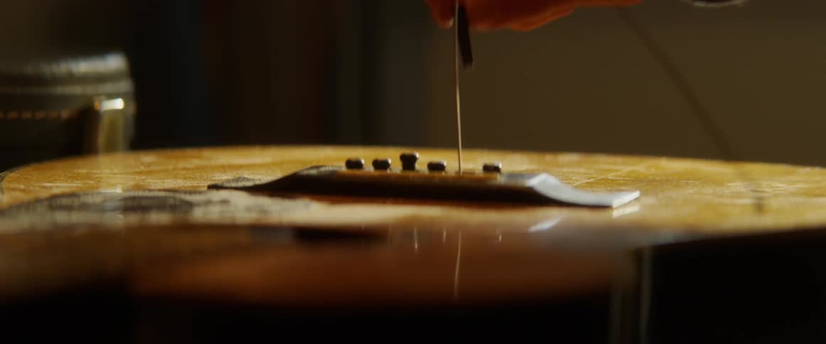 Man removes string from guitar