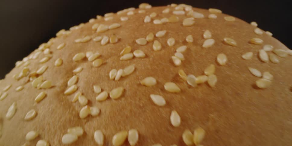 A pulled meat sandwich on a sesame seed bun
