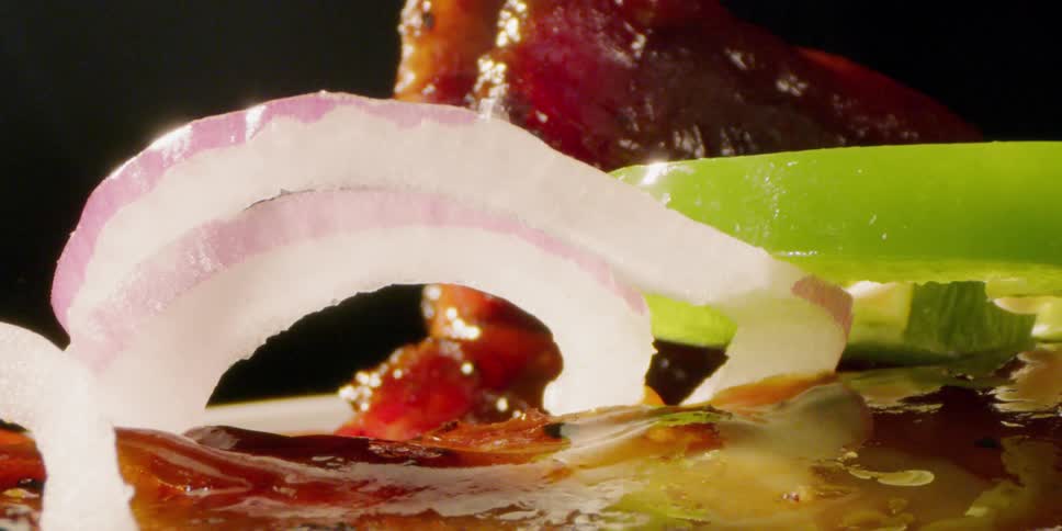 Onions and peppers piled in front of meat