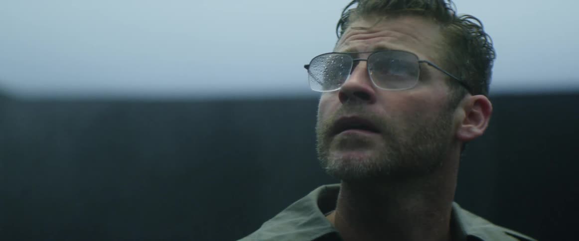 Man wearing glasses looks up and turns his head