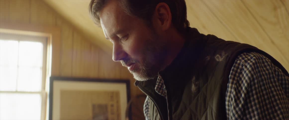 A man looks down at something in a room in a home