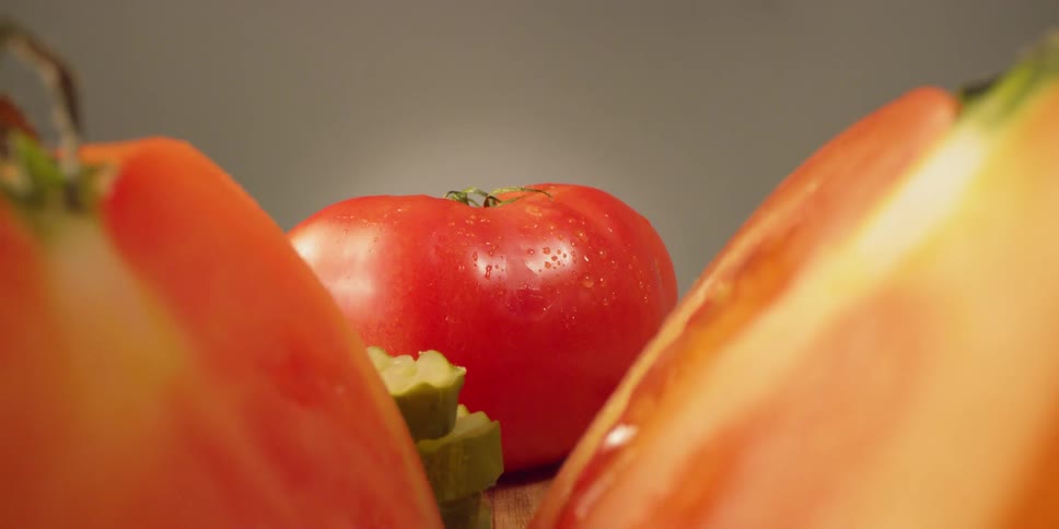 Water droplets shine off of several slices of tomatoes