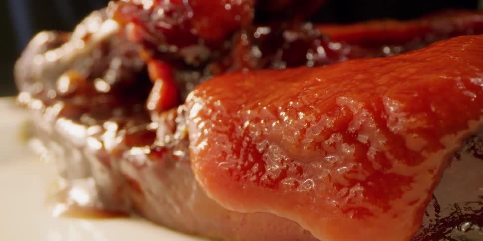 Meat on a plate with sauce being poured over it