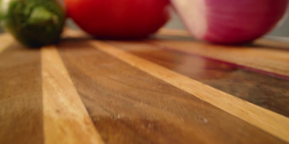 Vegetables sit on a wooden cutting board