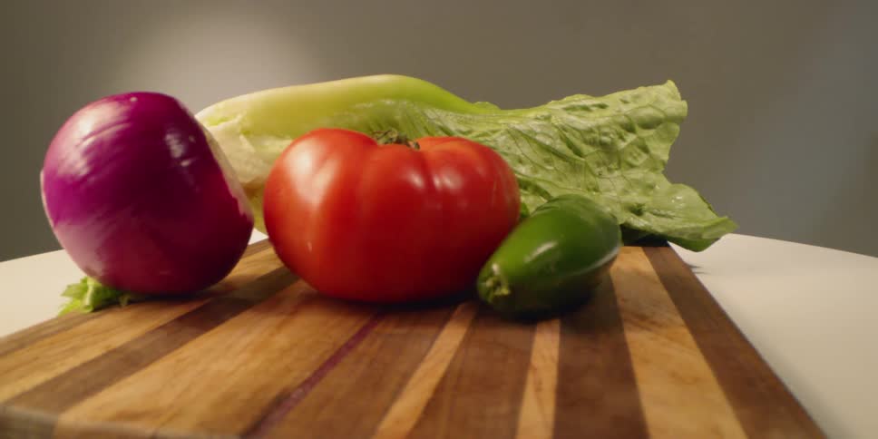 Vegetables sit on a wood cutting board
