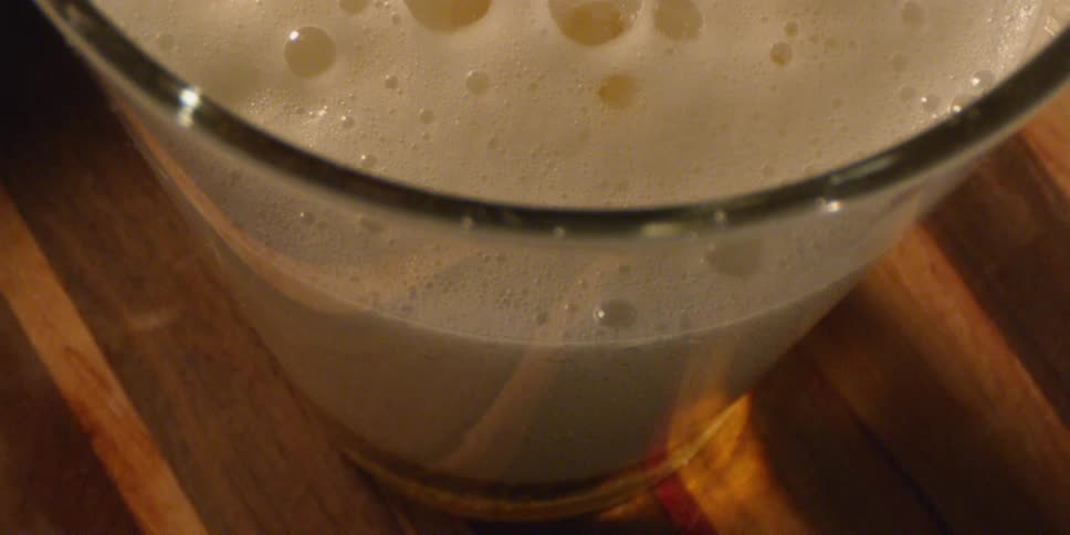 Liquid foams and fizzes in a glass on a table