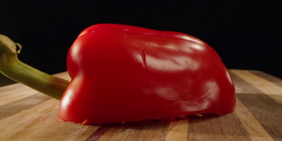 Half of a red pepper sits on the cutting board
