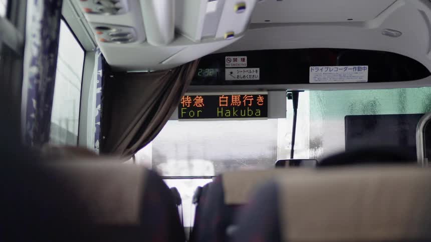 A commuter bus drives on a rainy day