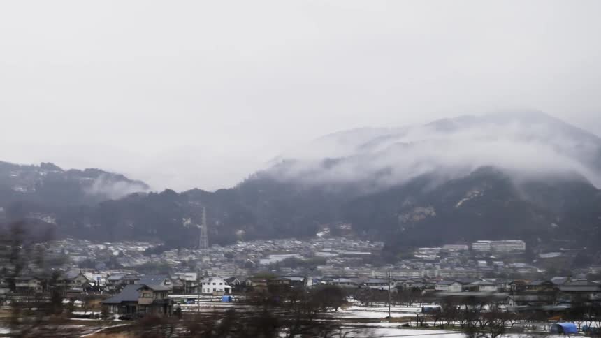 Many buildings in a city on a cloudy day in the mountains
