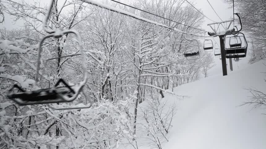 Ski lifts travel up and down the mountain over the snow
