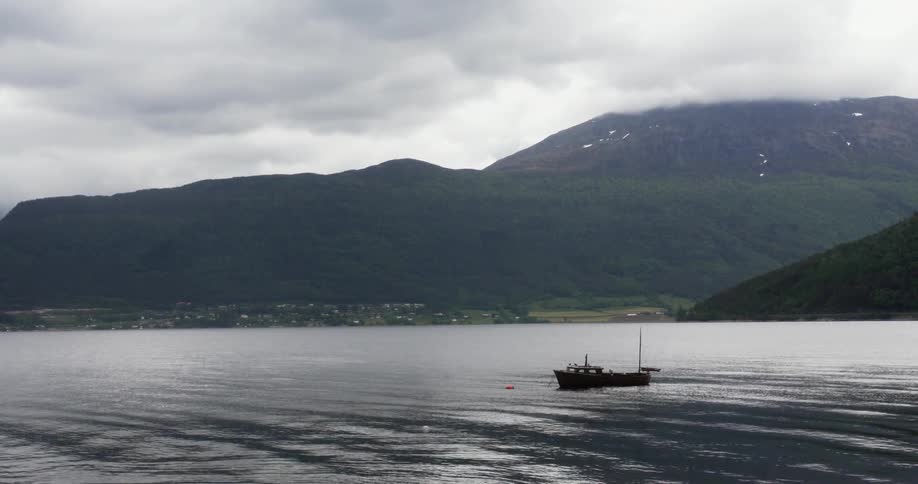 A boat floats on a rippling lake