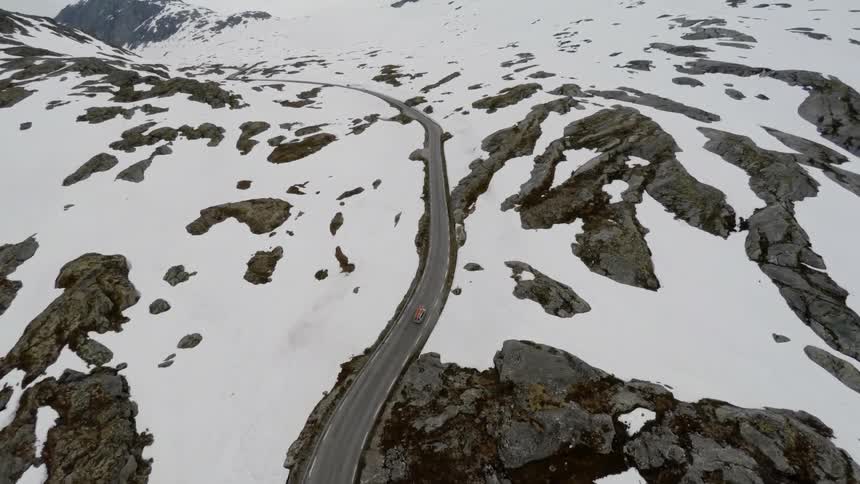A car drives on a curvy mountain road