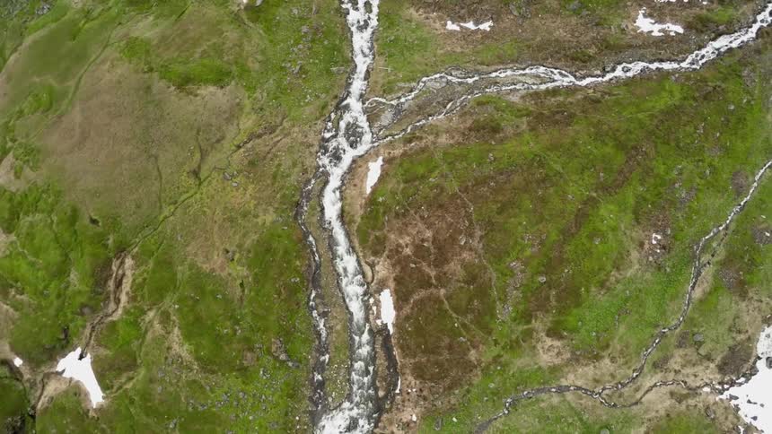 A bird's-eye-view of a river running over a hill