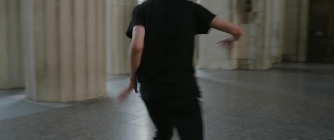 Person break dances near columns